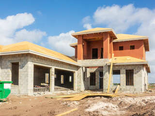 Upscale bi-level single-family house, with two-car garage, under construction in a suburban residential development on a sunny morning in southwest Florida