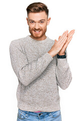 Wall Mural - Young redhead man wearing casual winter sweater clapping and applauding happy and joyful, smiling proud hands together