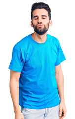 Wall Mural - Young handsome man with beard wearing casual t-shirt looking at the camera blowing a kiss on air being lovely and sexy. love expression.