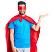 © Krakenimages.com - Young handsome man with beard wearing super hero costume smiling cheerful presenting and pointing with palm of hand looking at the camera.