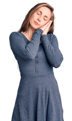 Canvas Print - Young beautiful blonde woman wearing casual dress sleeping tired dreaming and posing with hands together while smiling with closed eyes.