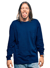 Sticker - Handsome caucasian man with long hair wearing casual winter sweater sticking tongue out happy with funny expression. emotion concept.