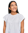 © Krakenimages.com - Young asian woman wearing casual white t shirt looking away to side with smile on face, natural expression. laughing confident.