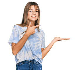 Wall Mural - Teenager caucasian girl wearing casual clothes amazed and smiling to the camera while presenting with hand and pointing with finger.