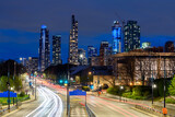 Fototapeta Big Ben - View of a urban road through a park with residential towers in background in Chicago downtown at twilight