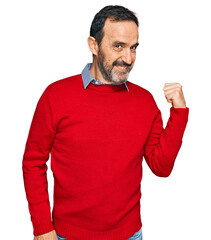 Poster - Middle age hispanic man wearing casual clothes smiling with happy face looking and pointing to the side with thumb up.