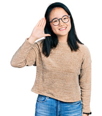 Wall Mural - Young chinese woman wearing casual sweater and glasses waiving saying hello happy and smiling, friendly welcome gesture