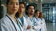 © ProPhotos - A diverse group of doctors stand in a row with their arms crossed, including a woman of Asian descent in the foreground.