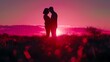 Young couple in love. Silhouette of a young couple holding each other and kissing against a pink scenery sunset sky on a meadow field. A romantic scene of a man and a woman at a pink summer night.