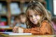 © Pinklife - Cheerful young girl with pencil in hand, smiling gently at the camera in a vibrant classroom setting