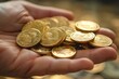 A person holding a handful of gold coins in their hand with a blurred background of gold coins in