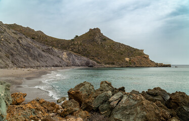 Wall Mural - Wild and lonely beach, surrounded by cliffs