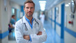Portrait of friendly middle aged European male doctor in workwear with stethoscope on neck posing with folded arms in clinic interior. Doctor Man With Stethoscope In Hospital. Copy space