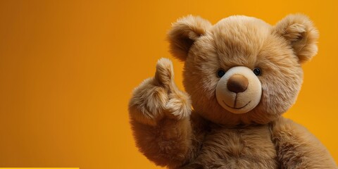 Sticker - cute plush teddy bear points finger at copy space on a orange isolated background