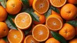 Slices of fresh ripe orange fruits with green leaves as a textural background, full screen close-up, top view.