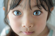 Close-up of an Asian girl child with beautiful eyes and surprised face