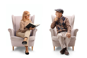 Wall Mural - Woman sitting in an armchair and reading a book to an elderly man