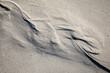 Photographie de l'estran, espace laissé à marée basse par la marée haute et des dessins abstraits laissés par la mer sur le sable.
