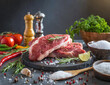 Raw meat on plate with cooking ingredients on decorated kitchen table