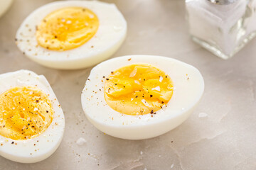 Wall Mural - Boiled eggs peeled and cut in half with salt and pepper