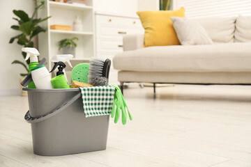 Sticker - Different cleaning supplies in bucket on floor at home, space for text