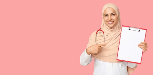 Sticker - Portrait of female Muslim doctor holding clipboard on pink background with space for text