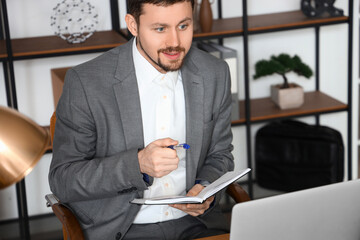 Canvas Print - Male tutor with notebook giving online lesson at home