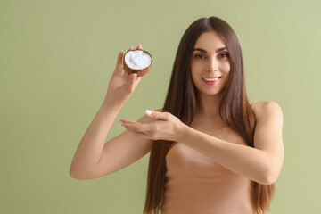 Canvas Print - Beautiful young woman with shell of coconut oil on green background