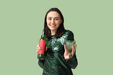 Poster - Beautiful young woman with glass and bottle of white wine on green background