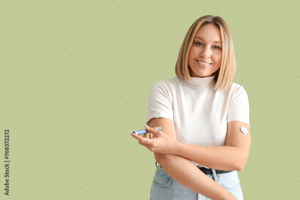 Diabetic woman using lancet pen on green background