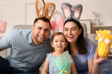 Poster - Happy family in bunny ears with Easter gifts sitting on floor at home