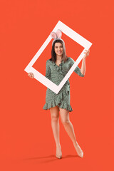 Wall Mural - Beautiful young woman in bunny ears with frame on orange background. Easter celebration