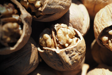 Wall Mural - A scoop of walnuts, a superfood, rests on a stack of nuts seeds
