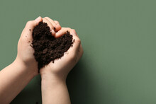 Female Hands Holding Soil In Shape Of Heart On Green Background, Closeup. Earth Day Celebration.