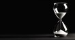 © James - Hourglass on a black background, shown in closeup view with copy space.