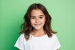© Chacmool - Portrait of a cute little girl smiling at the camera against a green background