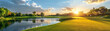 Peaceful golf course at sunset, ball close to water hazard, serene game moment