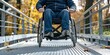 A man in a wheelchair is crossing a bridge