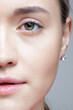 Closeup shot of human female face. Woman with nude makeup of eyes or no makeup.