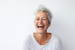 Portrait of a happy senior woman laughing against a white background.