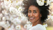 Portrait of an handsome black Afro American woman posing in front of a blooming cherry tree , close-up view of a cheerful beautiful African black middle aged female in an outdoor park