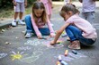 children drawing with chalk on park pavement