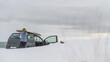 © Cavan Images - Woman removing surf board from roof of car