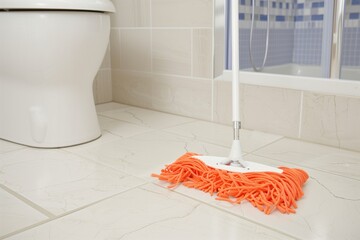 Poster - holding mop while cleaning bathroom floor