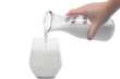Świeże mleko nalewane ze szklanego dzbanka do szklanki na białym tle