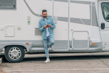 Fototapeta Panele - attractive traveler man with caravan and mobile phone