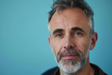 Canvas Print - Portrait of senior man with grey beard and mustache against blue background