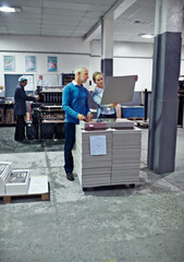 Poster - Printing, factory and man and woman with paper for teamwork, collaboration or product inspection. Warehouse, supply chain and people for logistics, manufacturing and industrial production in workshop