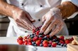 chef arranging a mix of berries into a neat mound