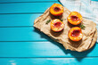 Baked peaches with honey and cinnamon on blue wooden background. summer dessert. Top view and copy space.